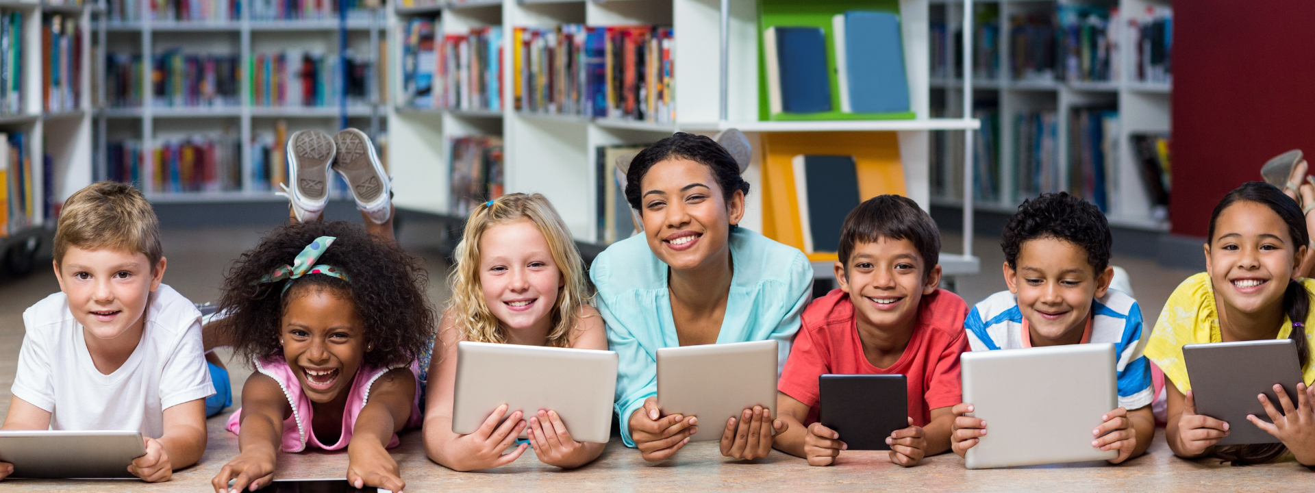 Substitute Smiling teacher with students using digital tablets